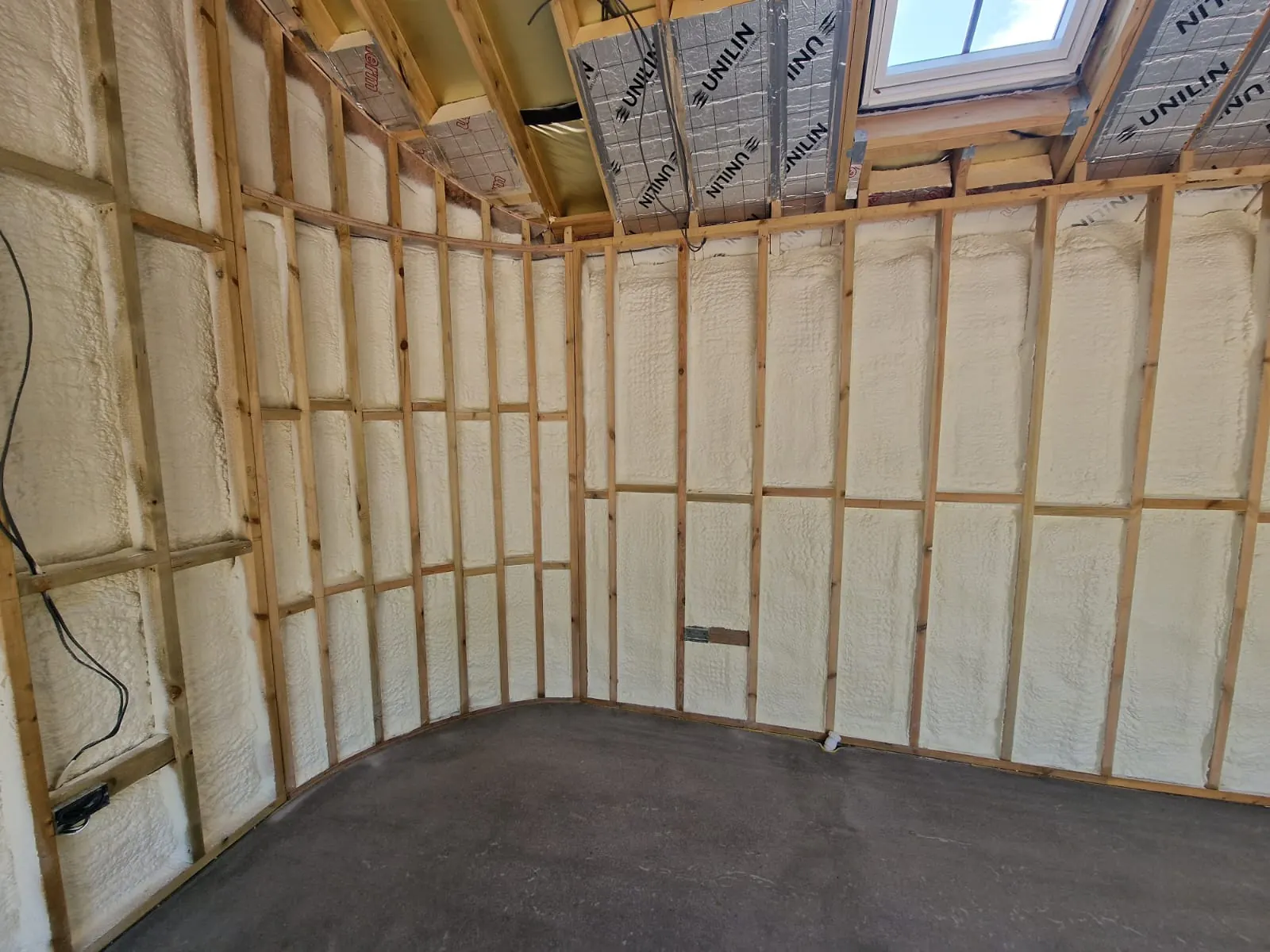 Spray foam insulation applied to stud walls — real Duratite Group project