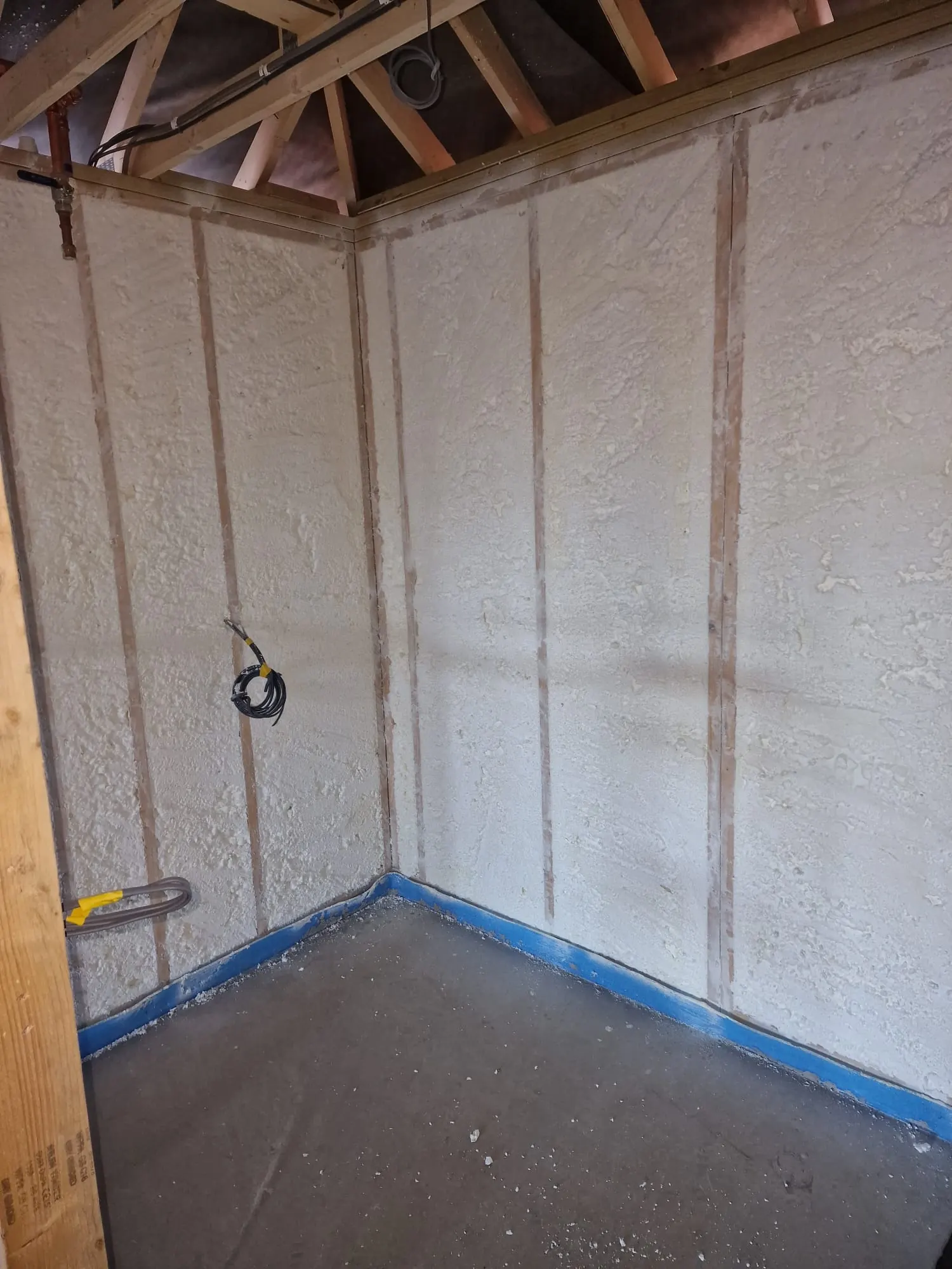 Spray foam insulation applied to stud walls — real Duratite Group project